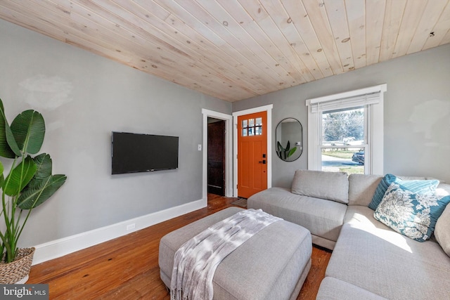 living area featuring baseboards, wood ceiling, and wood finished floors