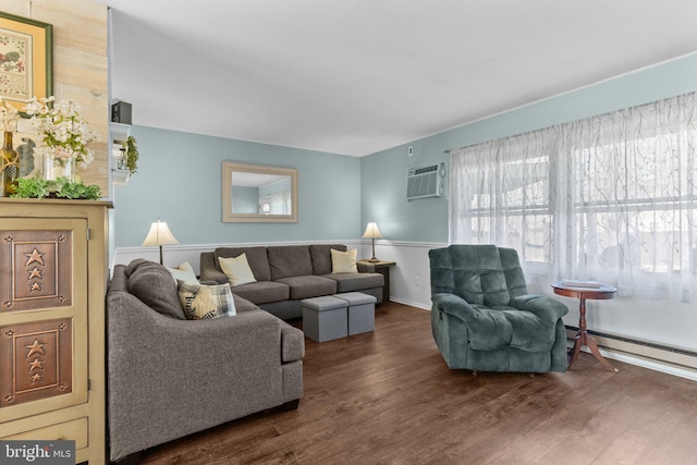 living area with a baseboard heating unit, wood finished floors, and a wall mounted AC