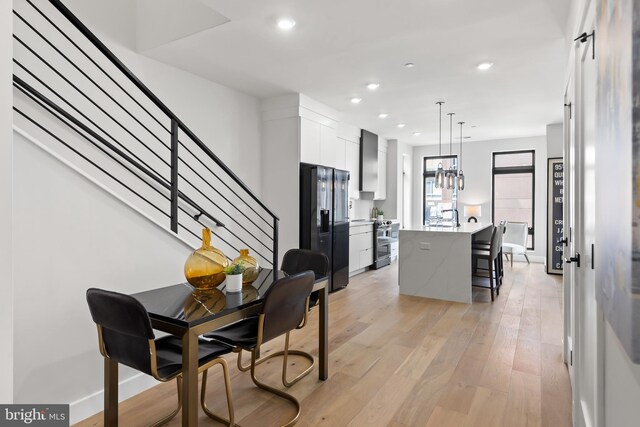 dining area featuring baseboards, recessed lighting, stairs, light wood-style floors, and a chandelier