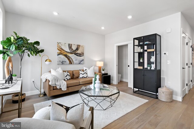 living room featuring recessed lighting, baseboards, and wood finished floors