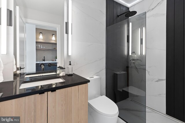bathroom featuring a marble finish shower, toilet, marble finish floor, and vanity