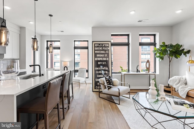 living room with light wood finished floors, visible vents, and recessed lighting