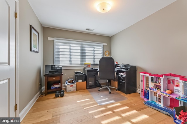 office space featuring wood finished floors, visible vents, and baseboards