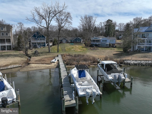 dock area featuring boat lift, a residential view, and a water view