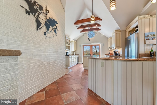 kitchen with high end fridge, brick wall, cream cabinets, and lofted ceiling with beams