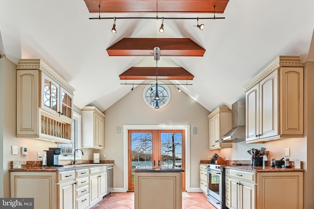 kitchen featuring dark countertops, cream cabinets, wall chimney exhaust hood, and stainless steel appliances