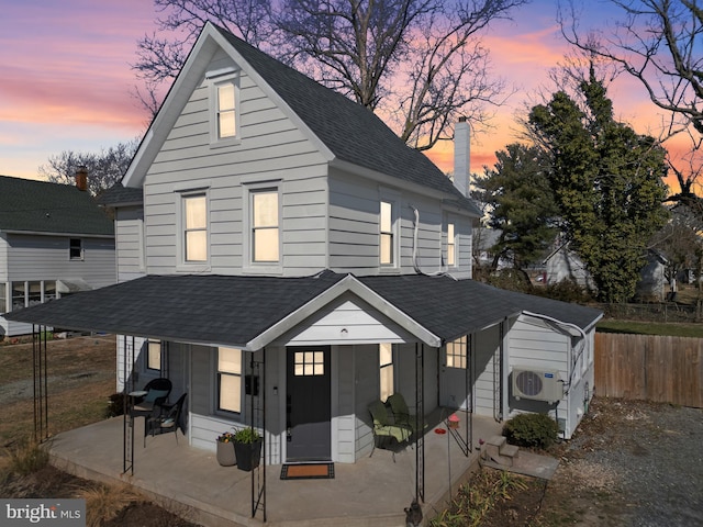 view of front of house featuring ac unit, fence, roof with shingles, a chimney, and a patio area