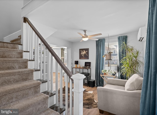 stairs with a wall mounted air conditioner, a ceiling fan, and wood finished floors