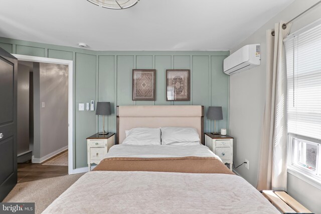 carpeted bedroom featuring a decorative wall and a wall mounted AC