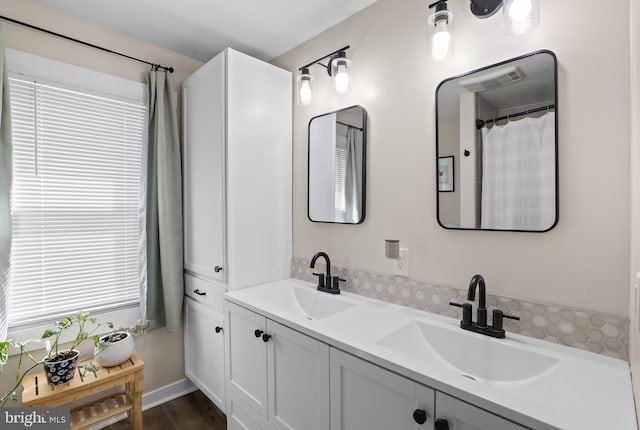 bathroom with a sink and double vanity