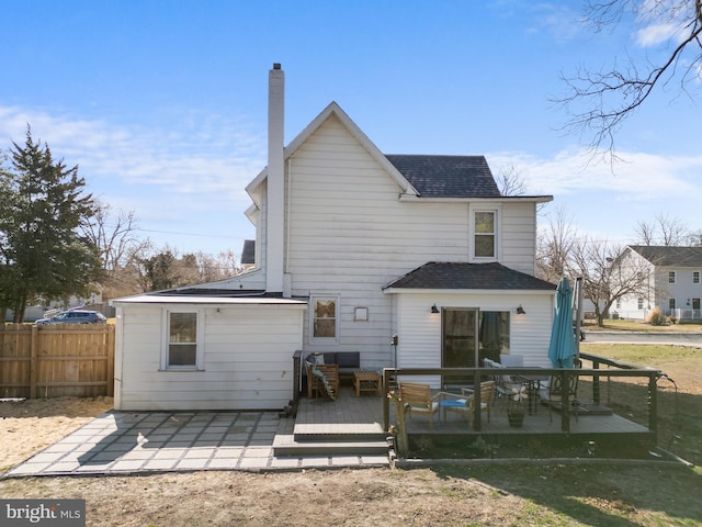 rear view of property featuring a patio area, fence, a chimney, and a shingled roof