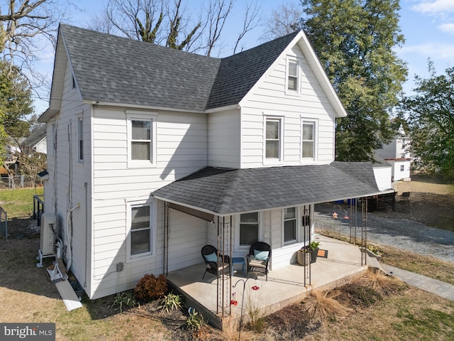 view of front of home featuring roof with shingles and a patio area