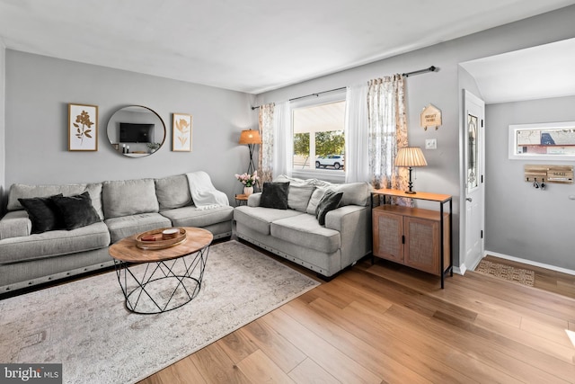 living area featuring light wood-type flooring and baseboards