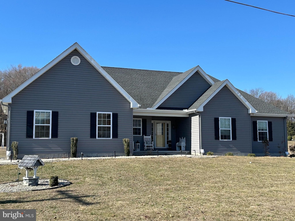 back of house featuring a porch, a lawn, and a shingled roof