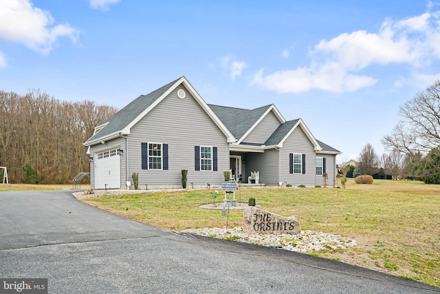 view of front facade featuring driveway, a front lawn, an attached garage, and a shingled roof