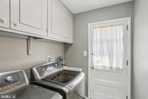 laundry room featuring cabinet space, washing machine and dryer, and a wealth of natural light