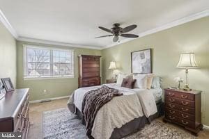 bedroom featuring ceiling fan, carpet, baseboards, and ornamental molding