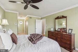 bedroom with baseboards, ornamental molding, and a ceiling fan