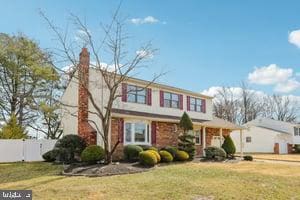 view of front of house featuring a front lawn and fence