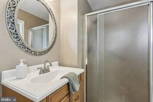 full bath with a shower stall and vanity