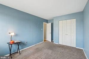 unfurnished bedroom featuring a closet, baseboards, and carpet floors