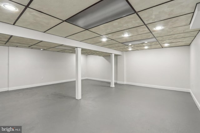 finished basement featuring recessed lighting, a paneled ceiling, and baseboards