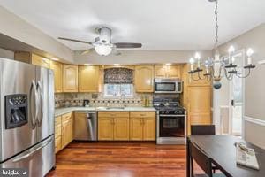 kitchen featuring a sink, stainless steel appliances, dark wood-type flooring, light countertops, and backsplash