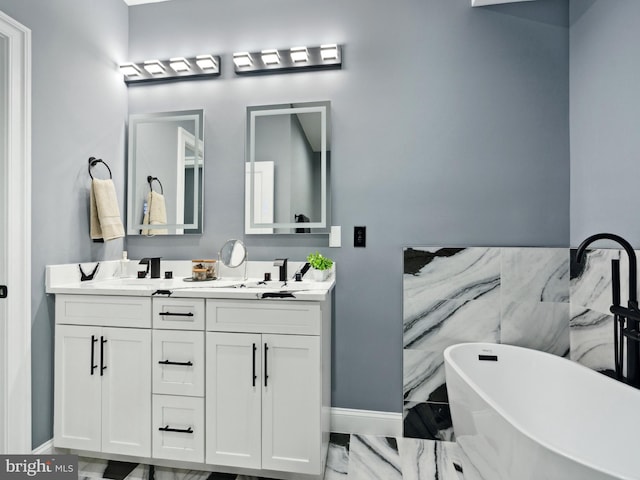 full bath with double vanity, a soaking tub, marble finish floor, and a sink