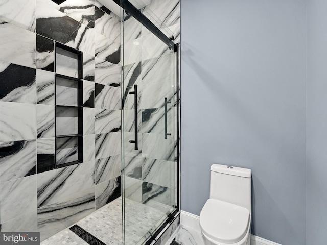 bathroom with toilet, marble finish floor, baseboards, and a marble finish shower