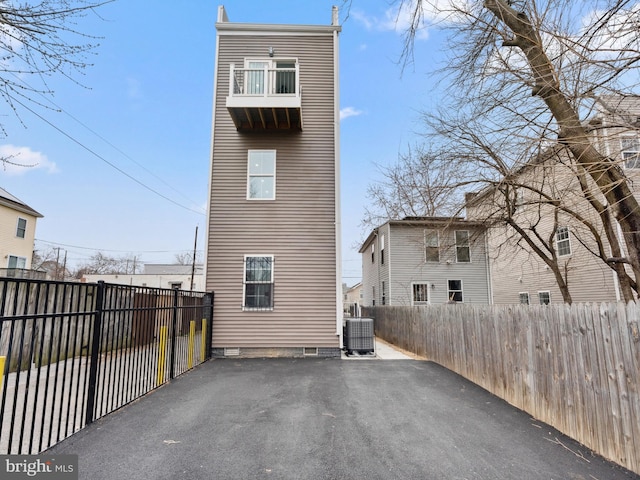 back of property with cooling unit, a patio, a fenced backyard, and driveway