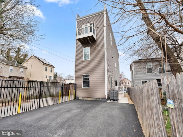 back of property featuring central air condition unit, a patio, a balcony, and fence