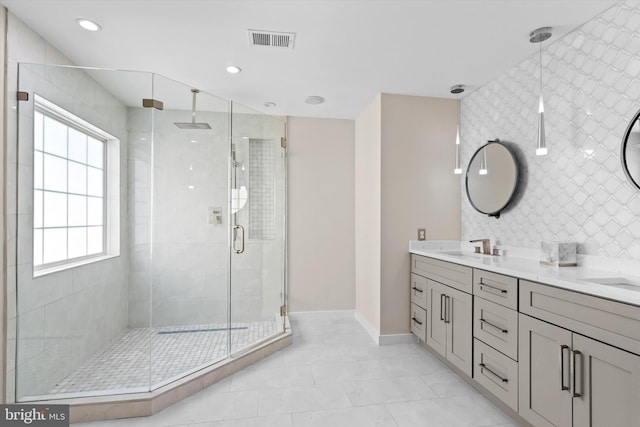 full bath featuring visible vents, double vanity, recessed lighting, a stall shower, and a sink