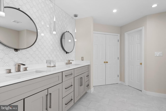 full bathroom with double vanity, visible vents, baseboards, and a sink