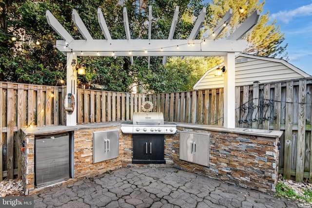 view of patio / terrace featuring area for grilling, a pergola, exterior kitchen, and a fenced backyard