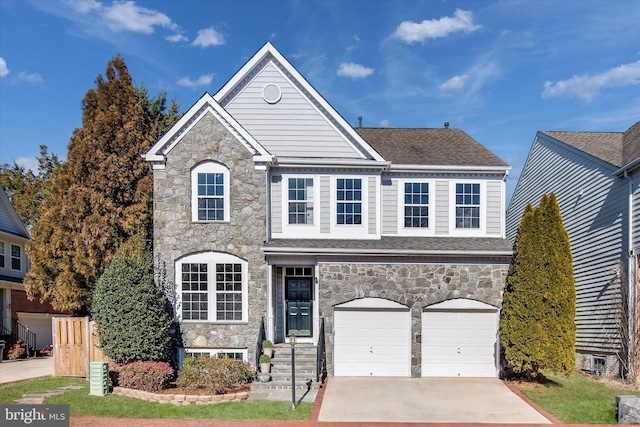 view of front facade featuring an attached garage, concrete driveway, roof with shingles, and fence