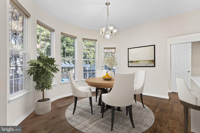 dining area featuring wood finished floors, baseboards, and a chandelier