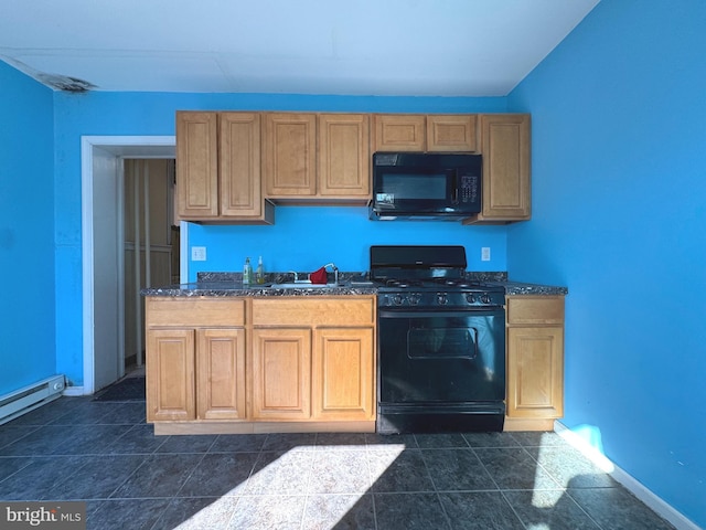 kitchen with dark countertops, baseboards, dark tile patterned floors, black appliances, and a sink