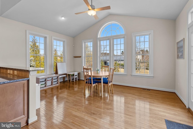 dining area with visible vents, baseboards, light wood-type flooring, lofted ceiling, and a ceiling fan