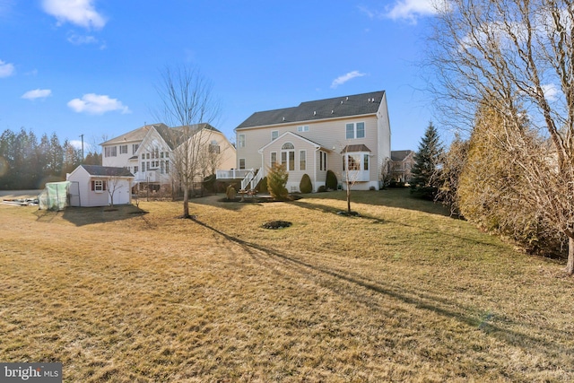 rear view of property featuring an outbuilding and a yard