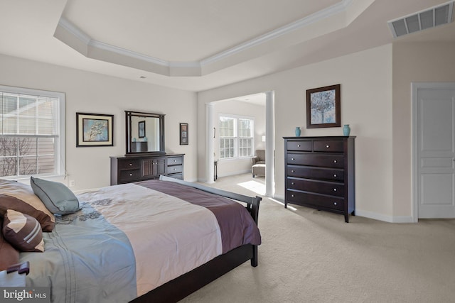 bedroom with visible vents, crown molding, baseboards, a tray ceiling, and light carpet