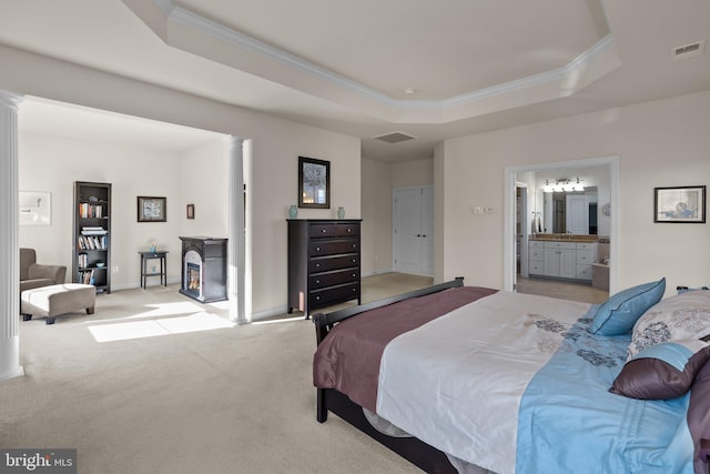 bedroom featuring a raised ceiling, crown molding, ornate columns, and light carpet