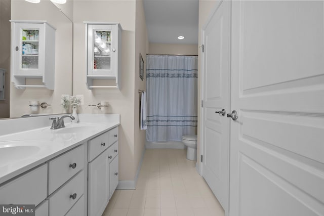 full bath featuring tile patterned flooring, double vanity, toilet, and a sink