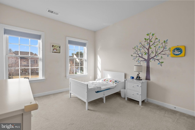 bedroom featuring visible vents, light carpet, and baseboards