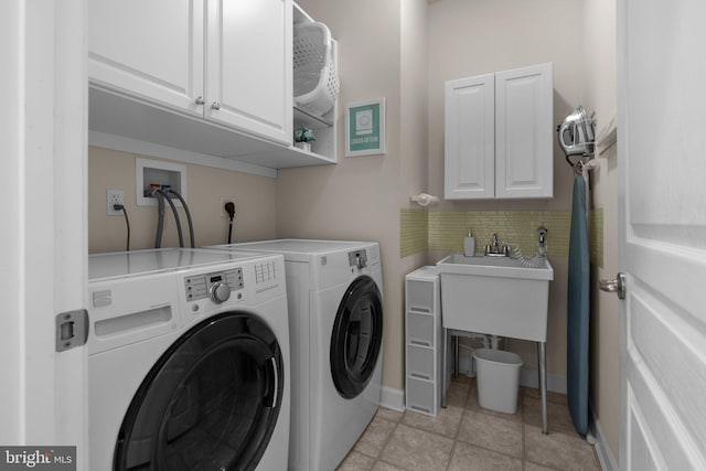 laundry room featuring light tile patterned floors, baseboards, cabinet space, and independent washer and dryer