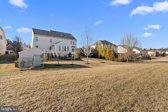 back of house featuring an outbuilding and a lawn