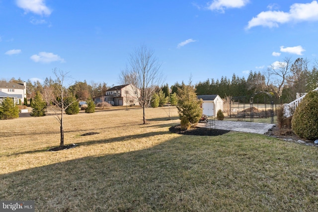 view of yard with a storage shed, an outdoor structure, and fence