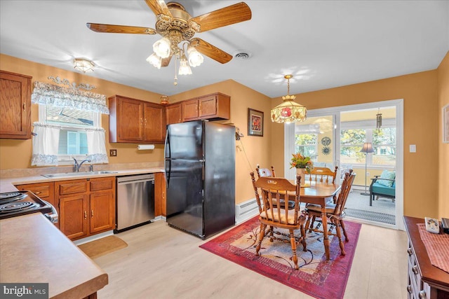 kitchen featuring a sink, stainless steel dishwasher, a wealth of natural light, and freestanding refrigerator