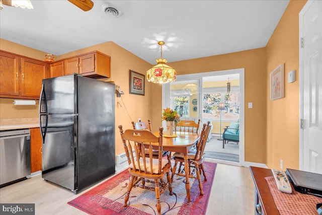 dining room with baseboards, visible vents, and light wood-type flooring