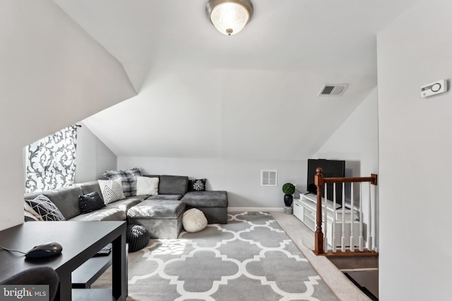 living room featuring vaulted ceiling, carpet, and visible vents