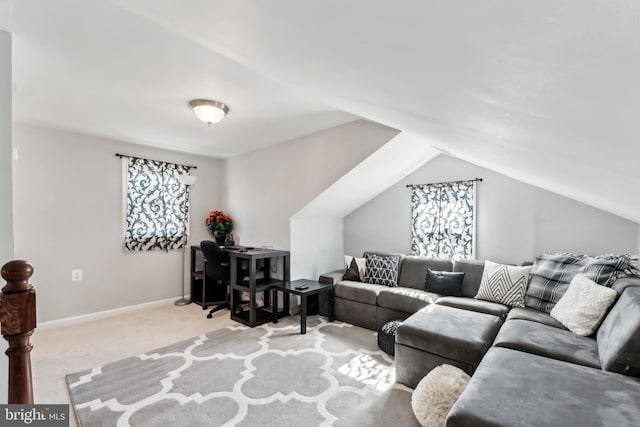 carpeted living room featuring vaulted ceiling and baseboards